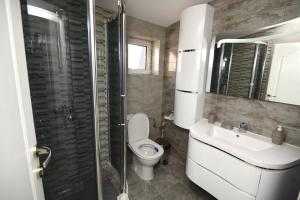 a bathroom with a toilet and a sink and a shower at Kate Apartments in Ohrid