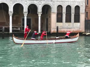 a group of people in a boat in the water at La Felice Canal Grande in Venice