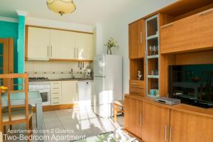 アルブフェイラにあるAkisol Albufeira Ocean IIのキッチン(白い冷蔵庫、木製キャビネット付)