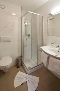 a bathroom with a shower and a toilet and a sink at Pension Hohenrainer in Reutte