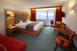 una camera d'albergo con letto e scrivania di Pension Hohenrainer a Reutte