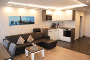 uma sala de estar com um sofá e uma cozinha em Terrassenhaus Penthouse-Wohnung 93 em Cuxhaven
