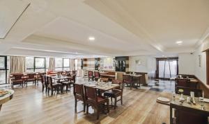 a restaurant with tables and chairs in a room at Monarch Brigade Road in Bangalore