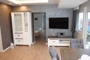 uma sala de estar com uma televisão de ecrã plano e um sofá em Terrassenhaus Penthouse-Wohnung 93 em Cuxhaven