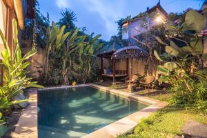 a swimming pool in the yard of a house at Gajah Biru Bungalows in Ubud