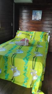 una cama amarilla con un animal de peluche sobre ella en le "BWA ' KAO", en Capesterre-Belle-Eau