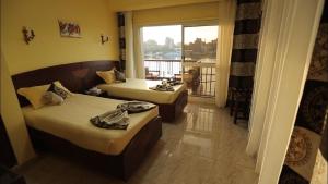 een hotelkamer met 2 bedden en een balkon bij Arabia Hotel in Caïro