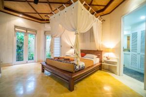 una camera da letto con un letto a baldacchino di Gajah Biru Bungalows ad Ubud Altre 70 foto