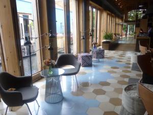 a lobby with chairs and tables in a building at Hotel Bo in San Cristóbal de Las Casas