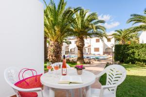 a white table with chairs and a book on a patio at Apartamento Las Palmeras in Cala Blanca