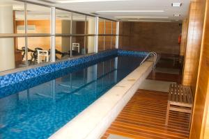 a large swimming pool with a bench in a building at Brasilia Boutique Flats in Brasília