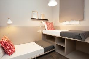 Habitación pequeña con 2 camas y espejo. en EasySleep Gaudi Terrace, en Barcelona
