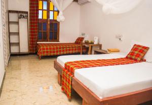 a hotel room with two beds and a chair at Stonetown View Hotel in Zanzibar City +30 photos