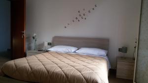 a bedroom with a bed with white pillows and birds on the wall at Rinaldi House in Torriana