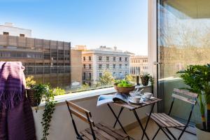 a balcony with a table and chairs and a window at Genteel Home Magdalena in Seville