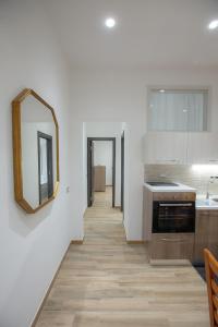 uma cozinha com paredes brancas e um espelho na parede em TaoMau - Duomo Square em Taormina