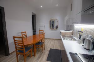 a kitchen with a wooden table and chairs and a counter at TaoMau - Duomo Square in Taormina