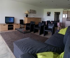 een woonkamer met banken en een flatscreen-tv bij Infinity I, 0405 in Oostende