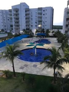 una gran piscina con palmeras frente a un edificio en Flat Lagoa Quente, en Caldas Novas