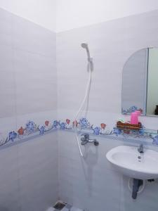 ein weißes Bad mit einer Dusche und einem Waschbecken in der Unterkunft Minh Hien Hotel in Vũng Tàu