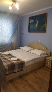 ラーヒフにあるZatishok Guest Houseのベッドルーム1室(壁に絵画が描かれたベッド1台付)