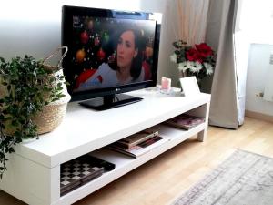 TV en un centro de entretenimiento blanco en una sala de estar en Ancient Porticciolo - Nervi Genova, en Génova