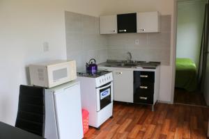 a small kitchen with a microwave and a stove at Complejo Costa Serena-Casas del Mar in La Paloma +26 photos