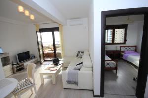 ein Wohnzimmer mit einem weißen Sofa und ein Schlafzimmer in der Unterkunft Karina Apartment in Budva
