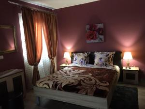 a bedroom with a bed with purple walls and two lamps at Archontiko Kirfis in Desfina in Dhesfína