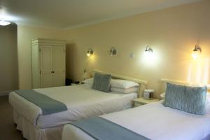 a hotel room with two beds and lights on the wall at Canterbury Hotel in Canterbury