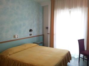 a bedroom with a bed and a large window at Hotel Garni' Alaska in Riccione