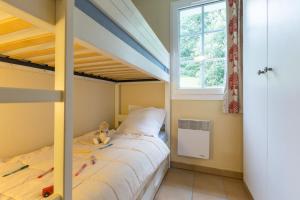 ein Kinderschlafzimmer mit einem Etagenbett und einem Fenster in der Unterkunft Résidence Pierre & Vacances Le Domaine de Bordaberry in Urrugne + 33 Fotos