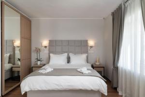 a bedroom with a large bed with two towels on it at Porto Vecchio Luxury Suites in Spetses