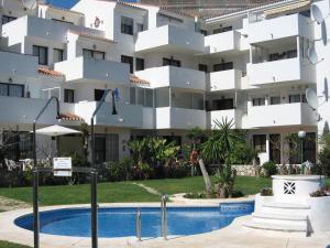 a building with a swimming pool in front of a building at Apartamentos SOL y PLAYA Torremolinos in Torremolinos