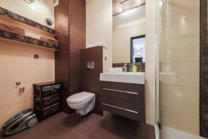 a bathroom with a toilet and a sink and a mirror at Apartamenty Polanica MyWeek in Polanica-Zdrój +127 photos