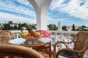 a bowl of fruit on a table on a balcony at Porto Vecchio Luxury Suites in Spetses