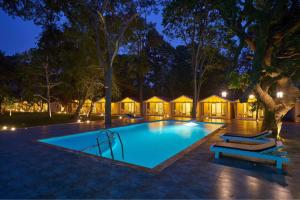 a swimming pool in a resort at night at Blu Resorts in Vagator