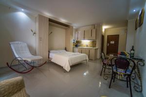 een slaapkamer met een bed, een stoel en een tafel bij Royal Apartments in Batoemi
