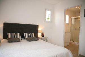 a bedroom with a large white bed with two pillows at Golf de Pont Royal Villa les Micocouliers climatisée 4 chambres Piscine chauffée Parking in Mallemort +16 photos