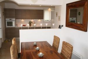 a kitchen with a wooden table and chairs at Golf de Pont Royal Villa les Micocouliers climatisée 4 chambres Piscine chauffée Parking in Mallemort