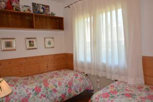 a bedroom with a bed and a window at GRAZIOSA BIFAMILIARE AD ASIAGO con giardino privato in Asiago