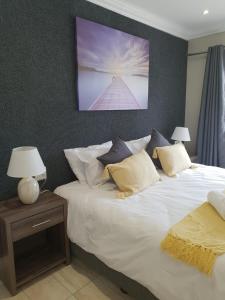 a bedroom with a large white bed with two lamps at Reef View BnB in East London
