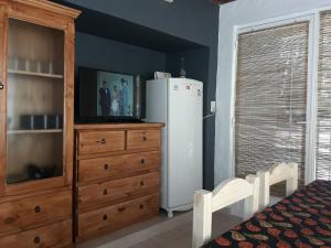 a kitchen with a refrigerator and a wooden dresser at Lo de Marito in Balneario Claromecó