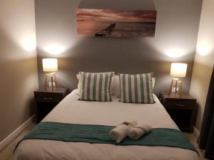 1 dormitorio con 2 lámparas y 1 cama con toallas. en Reef View BnB en East London