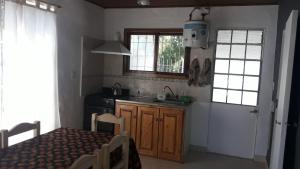 cocina con fregadero, fogones y ventanas en Lo de Marito en Balneario Claromecó