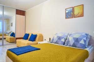 a bedroom with a large yellow bed with blue pillows at "GOOD NIGHT" on Ovrazhniy 17 in Tomsk