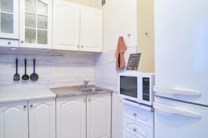 a white kitchen with a sink and a microwave at "GOOD NIGHT" on Ovrazhniy 17 in Tomsk