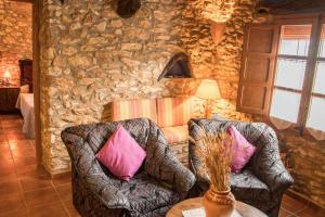 ein Wohnzimmer mit 2 Stühlen und einer Steinmauer in der Unterkunft Amborget in Sant Jordi