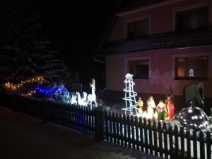 a fence with christmas lights in front of a house at U Gabryla in Biały Dunajec
