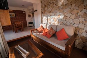 a living room with a couch and a stone wall at Haras del Bosque in Mar de las Pampas